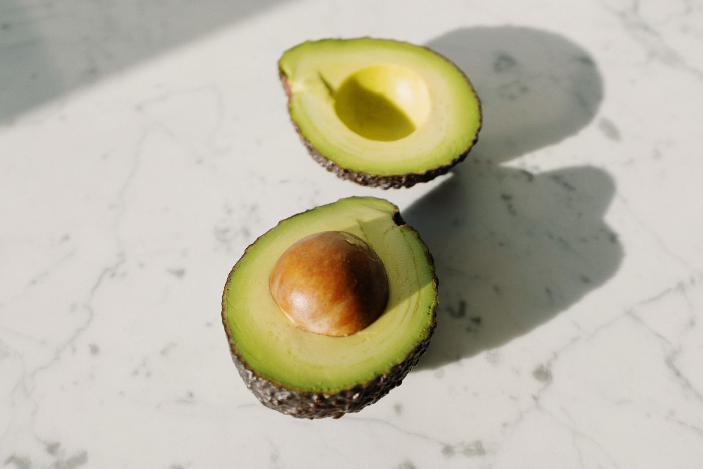 Halved avocado on a pale surface