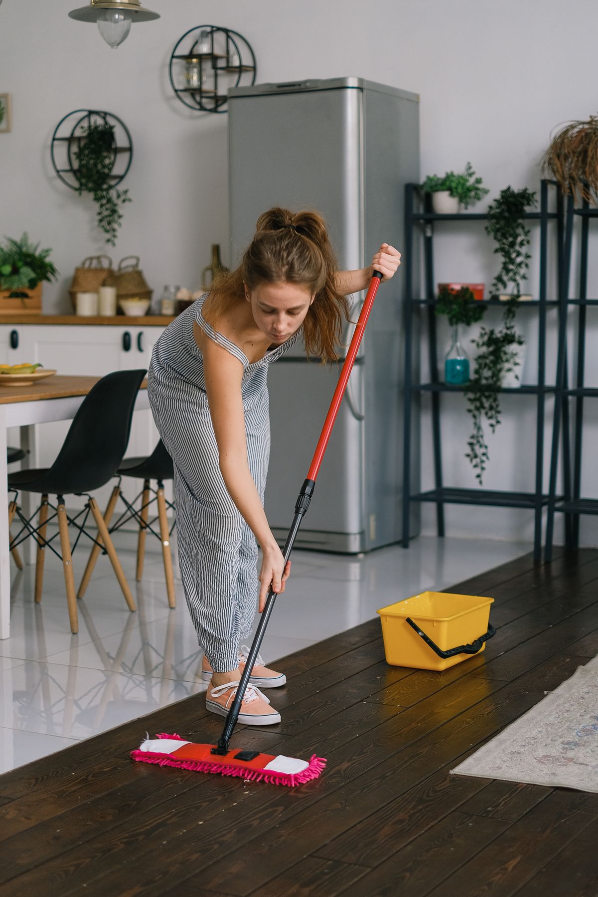 Person cleaning a floor with a mop in a home
