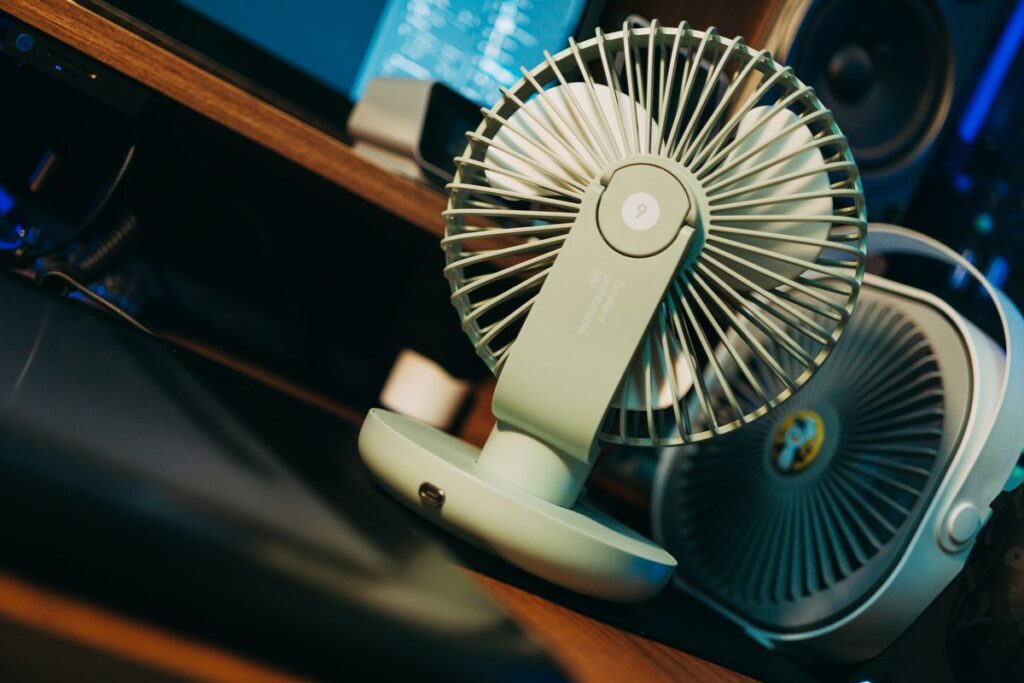 Compact desk fan at a computer workspace