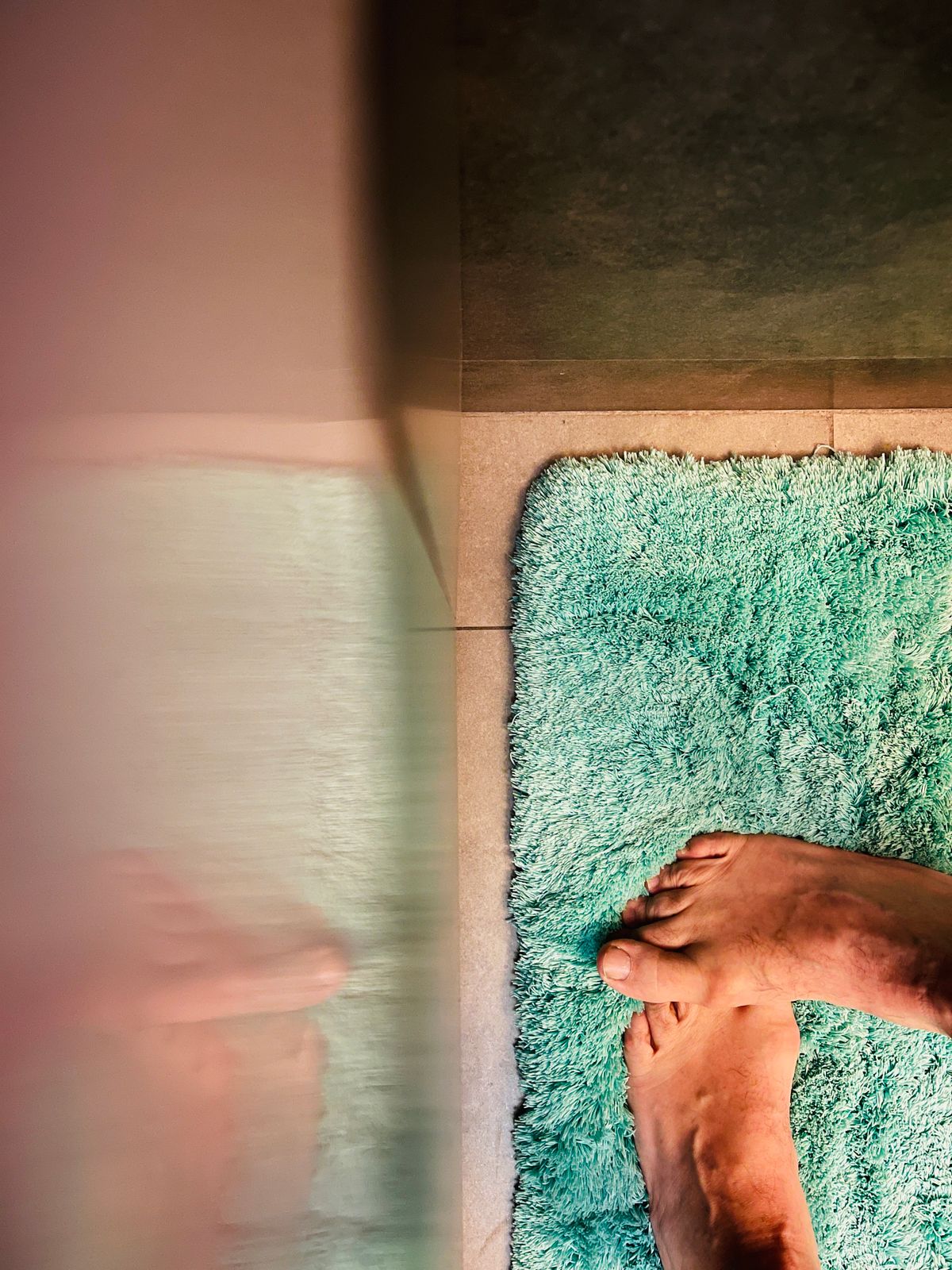 Person standing on a green bathroom mat