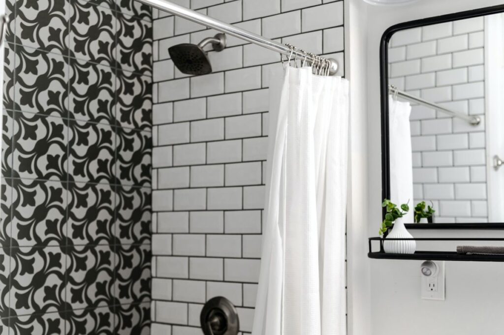 White shower curtain inside a tiled bathroom