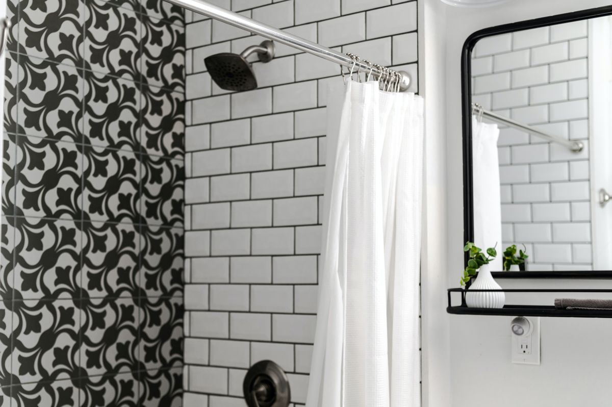White shower curtain inside a tiled bathroom