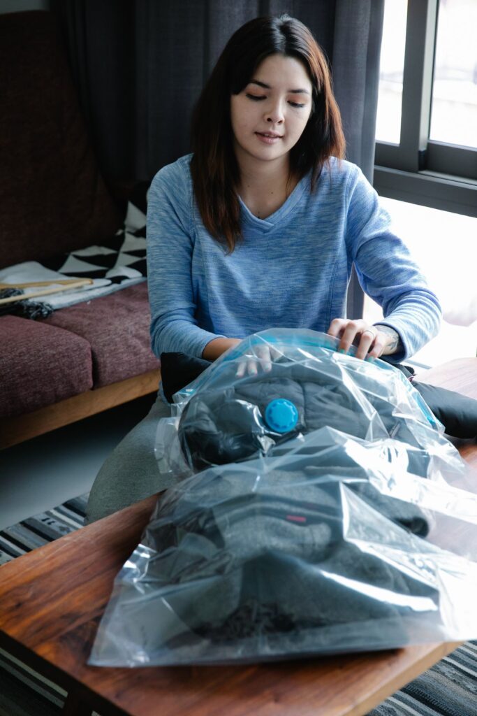 Person packing clothing with storage bags
