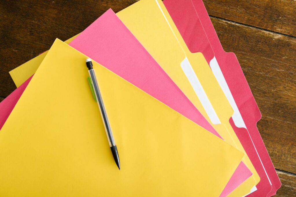 Colorful folders and a pen on a table