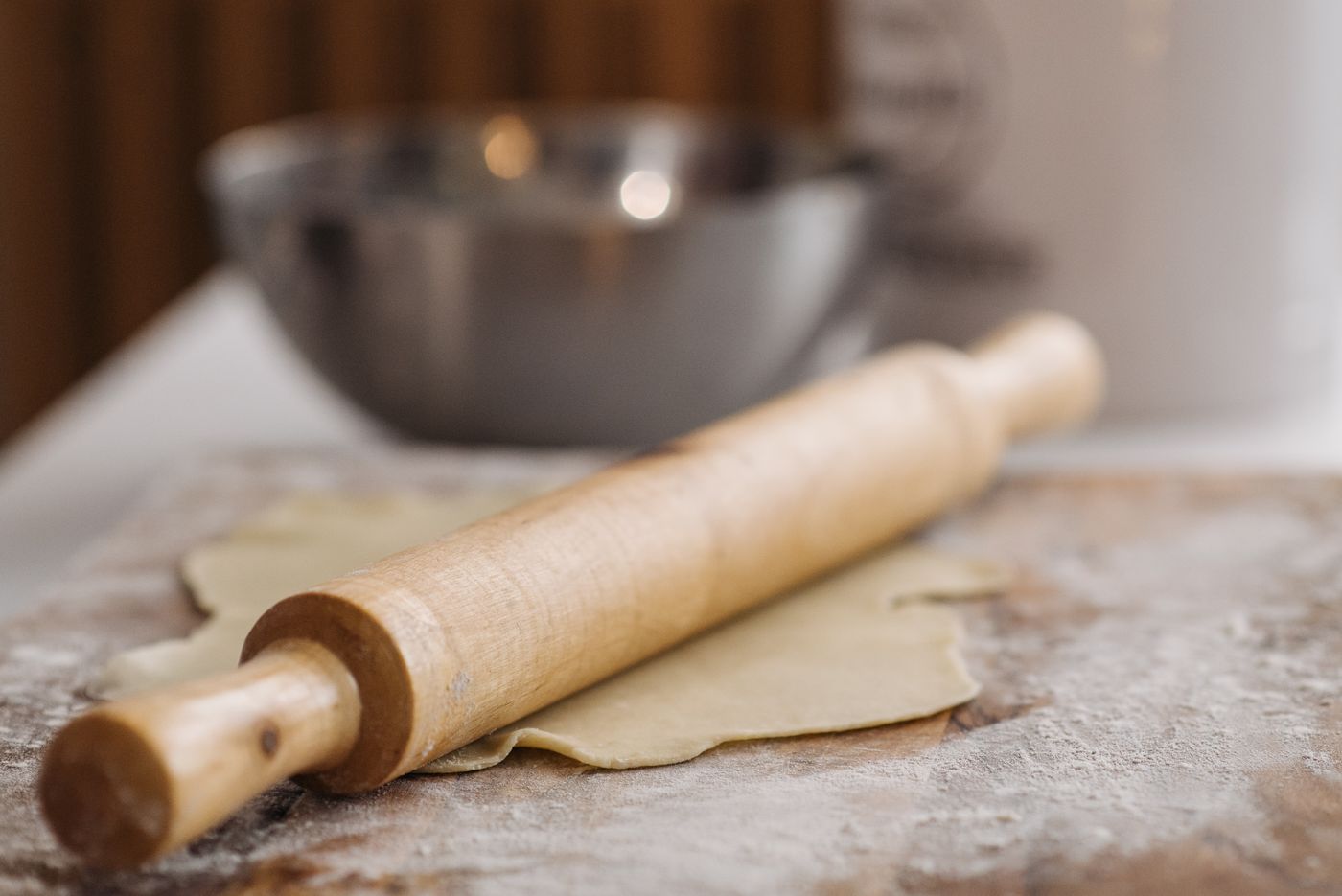 Wooden rolling pin resting on dough