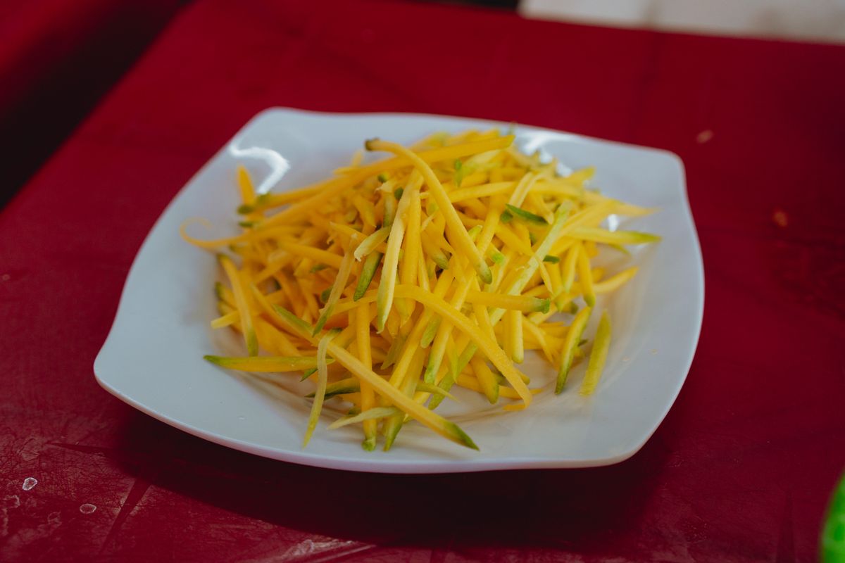 Fresh mango slices served on a white plate