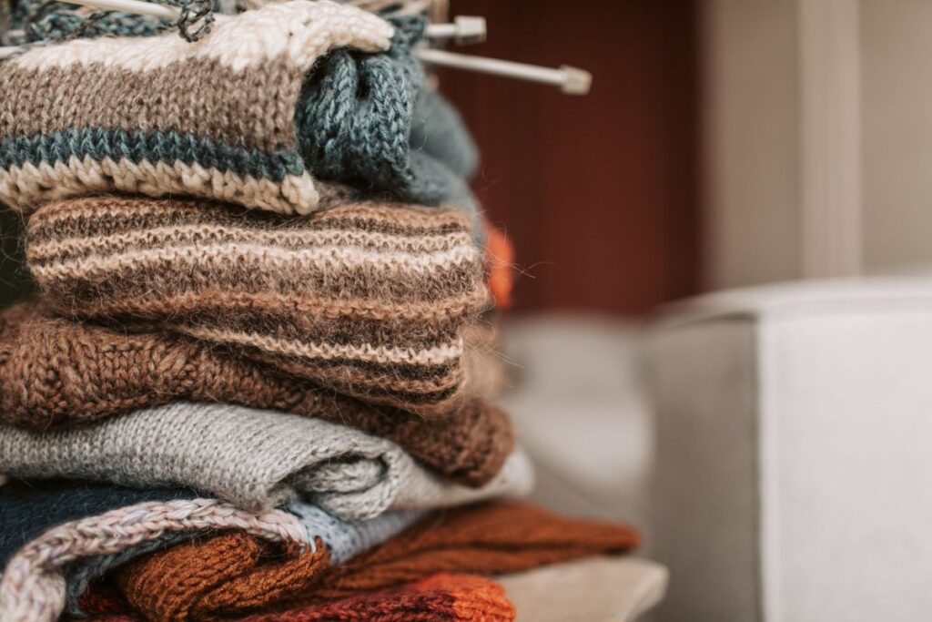 Folded knitted sweaters with knitting needles