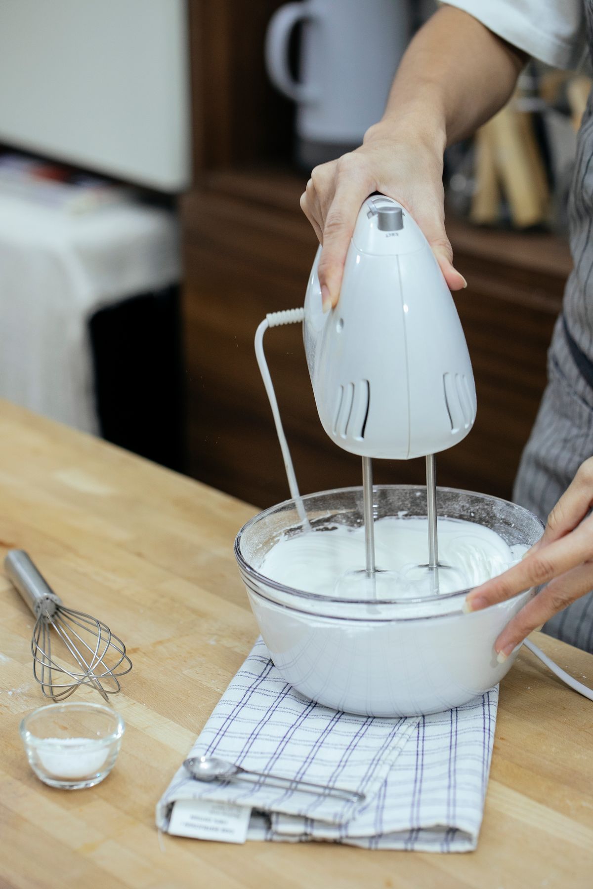 Person using a hand mixer in a mixing bowl