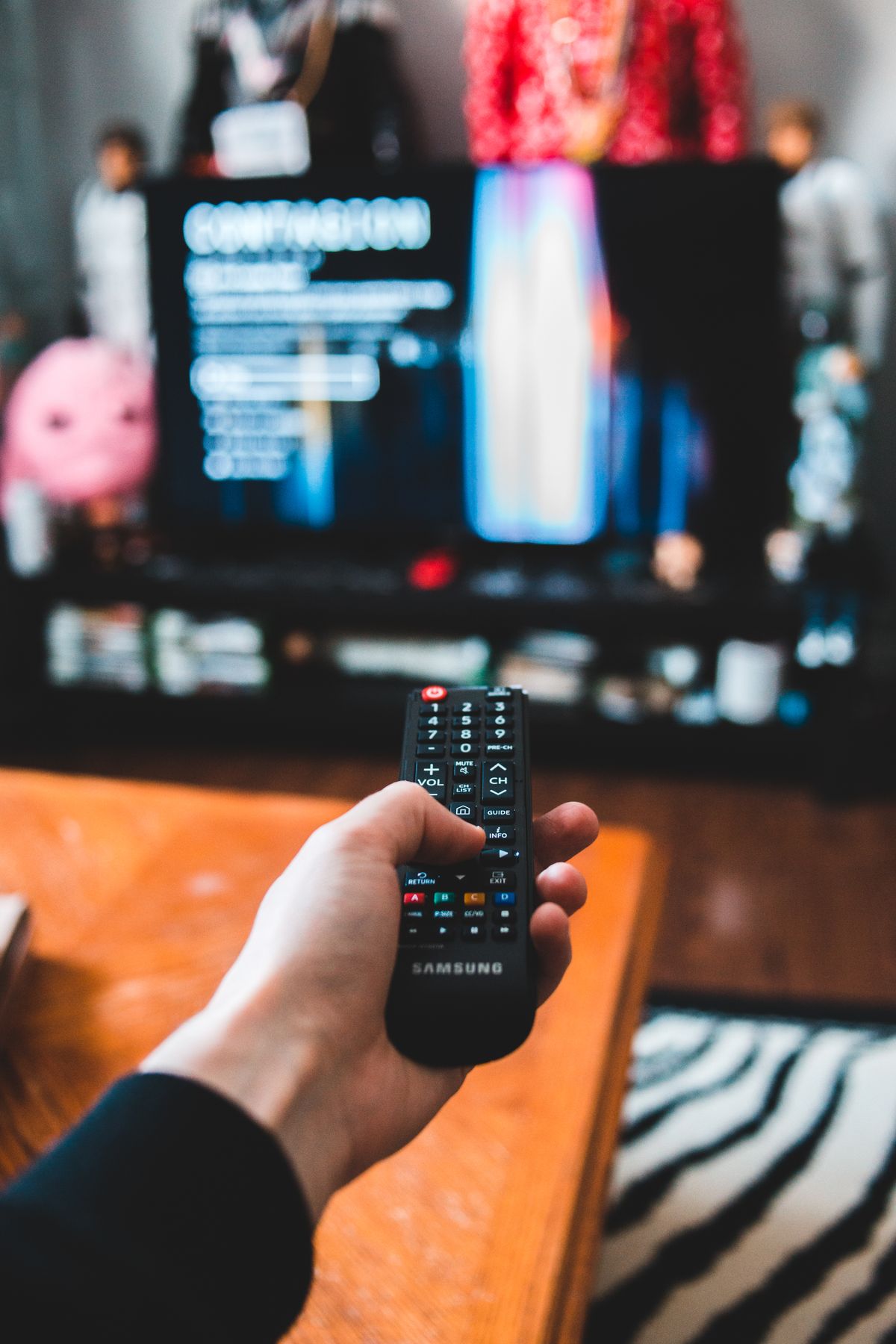 Person holding a TV remote in a living room