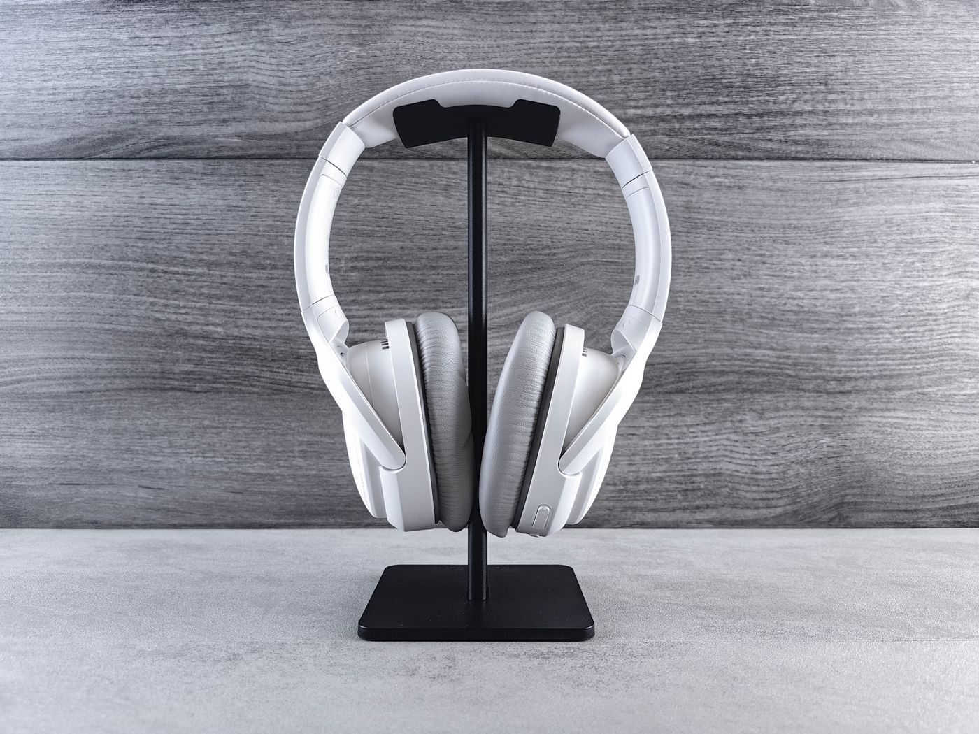 White headphones resting on a stand