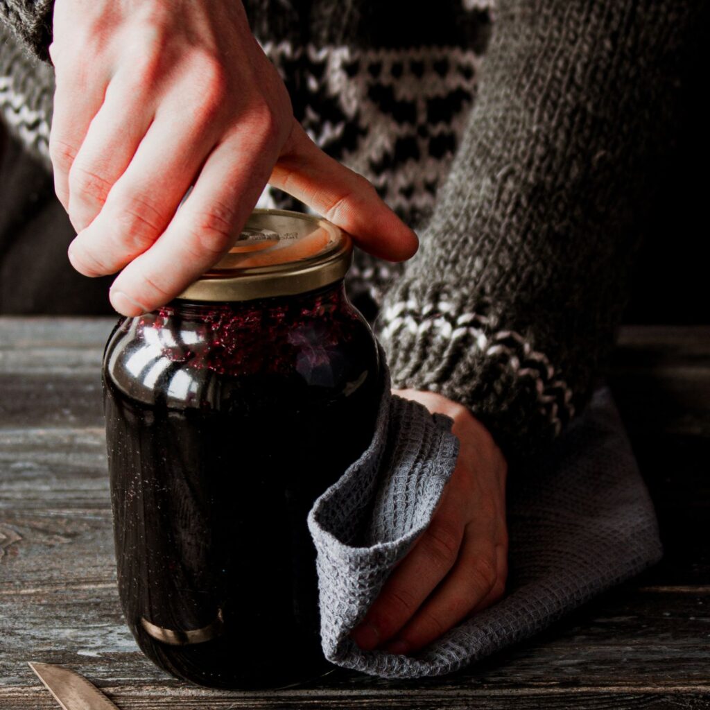 Hands opening a glass jar