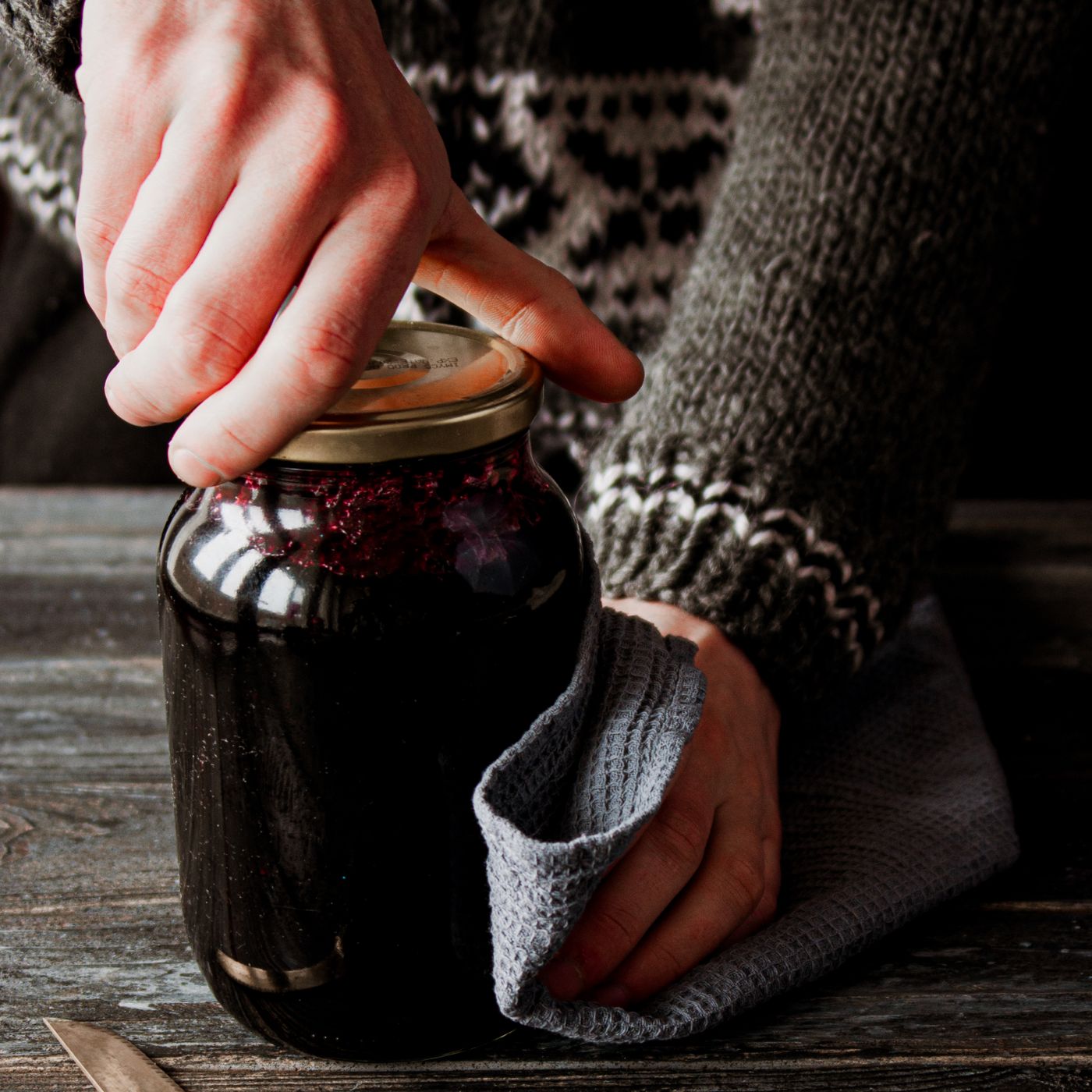 Hands opening a glass jar