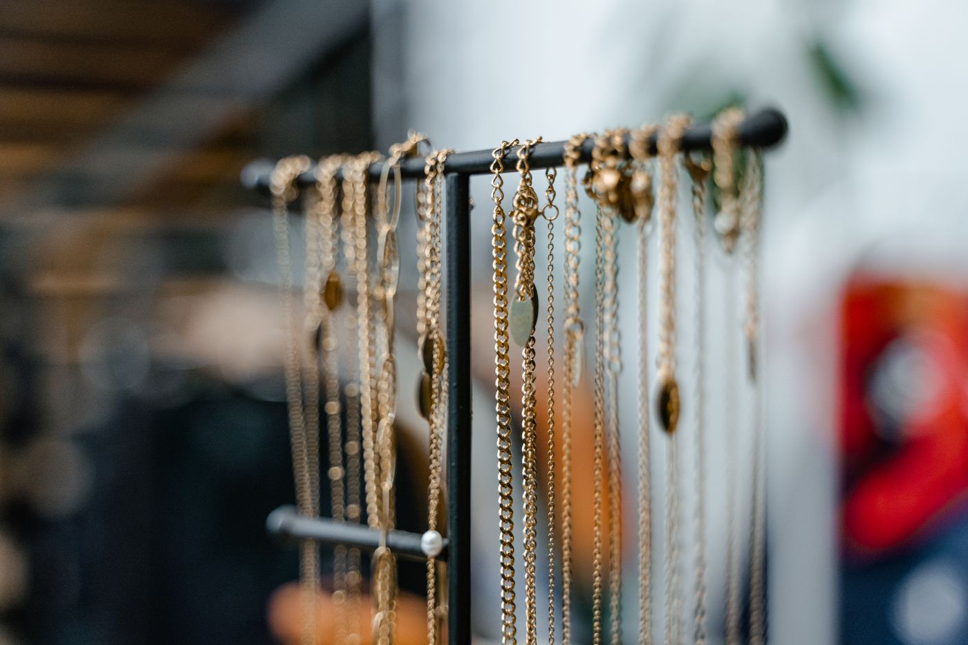 Gold necklaces hanging on a jewelry display stand
