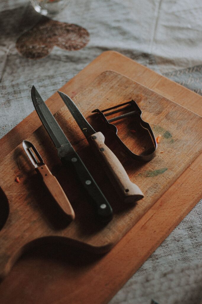 Kitchen knives and peelers on a wooden board