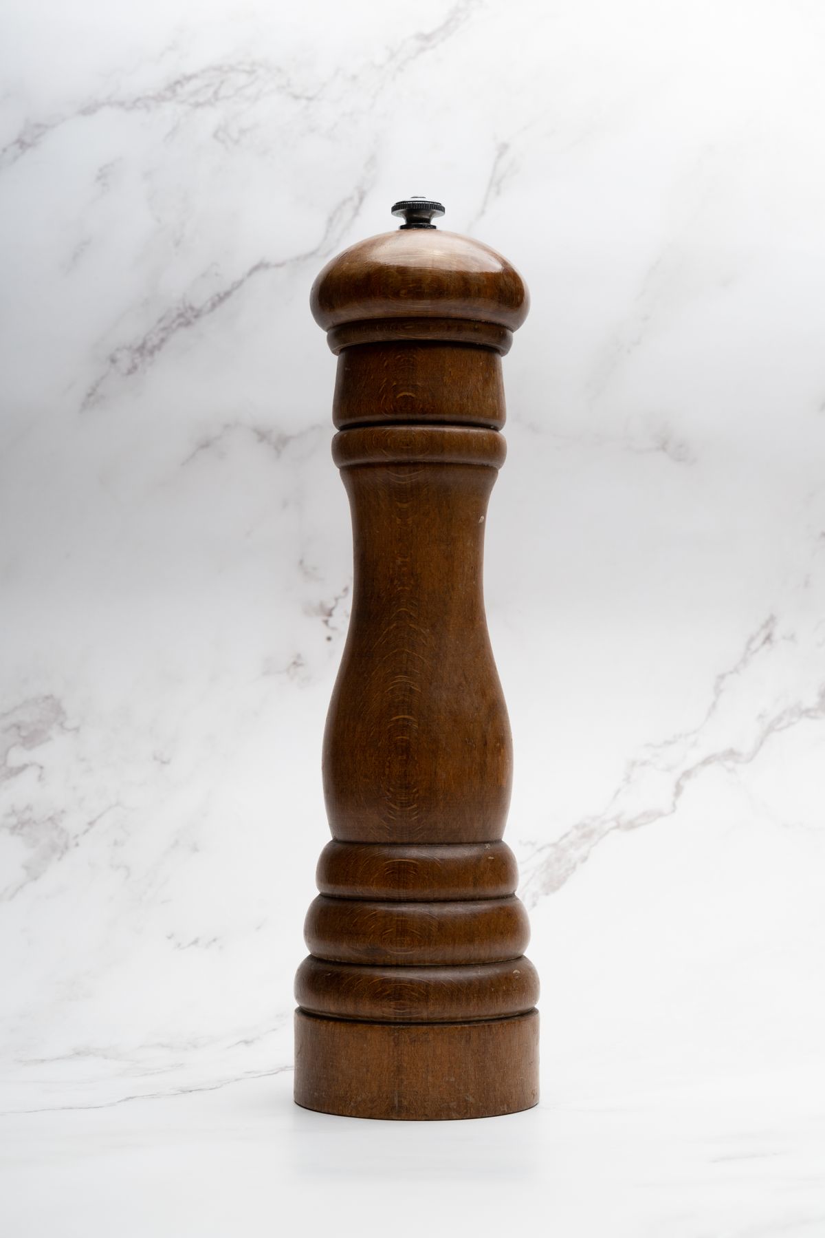 Wooden pepper mill on a light surface