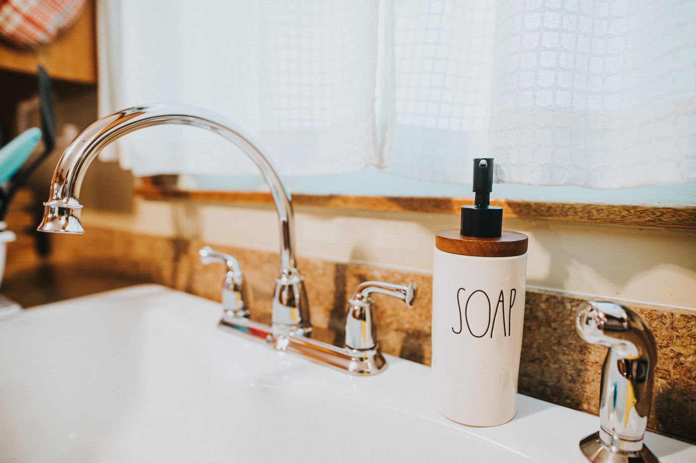 Soap dispenser beside a kitchen sink