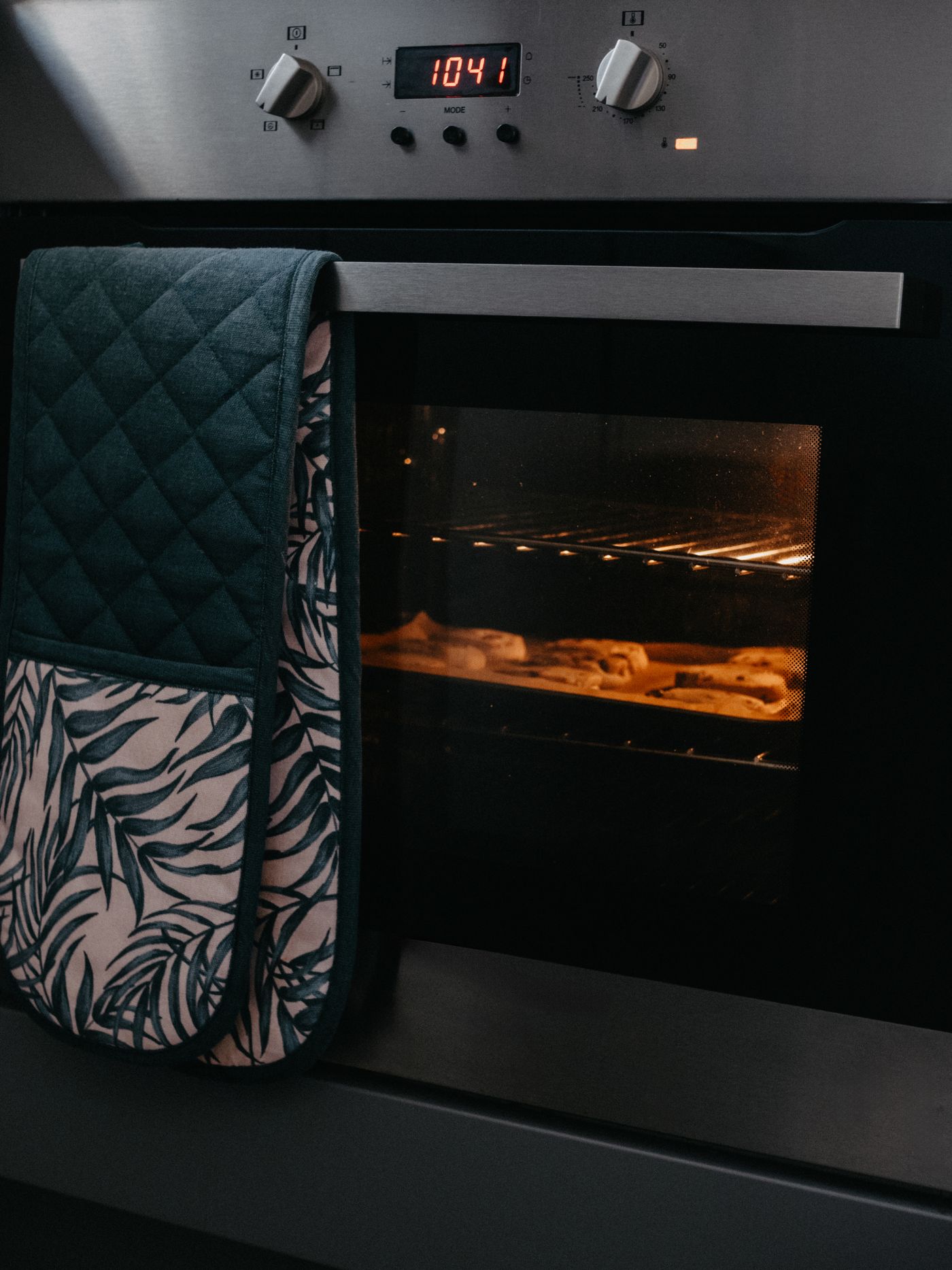 Kitchen oven with a mitt hanging from the handle