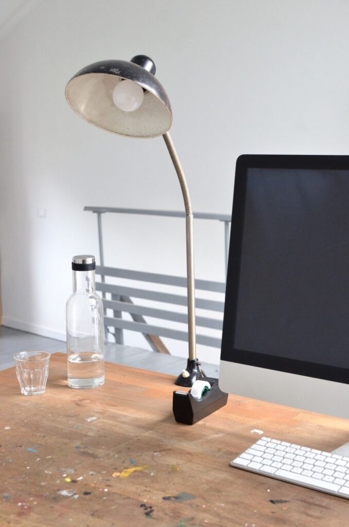 Desk lamp beside a computer monitor