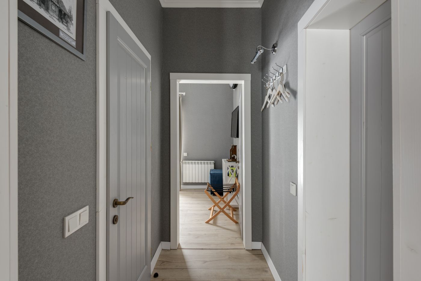 Home hallway with grey walls and wooden doors