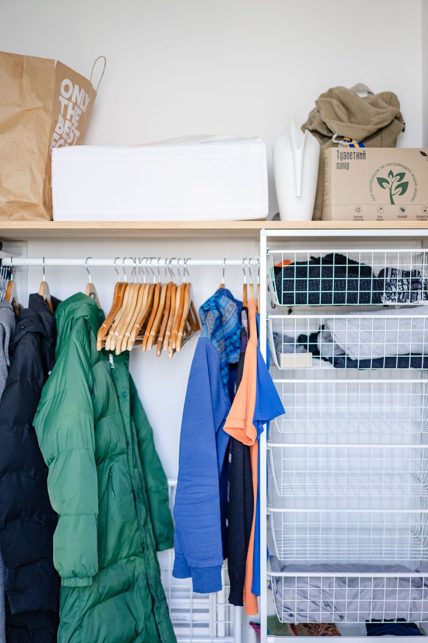 Clothes on hangers inside a wardrobe