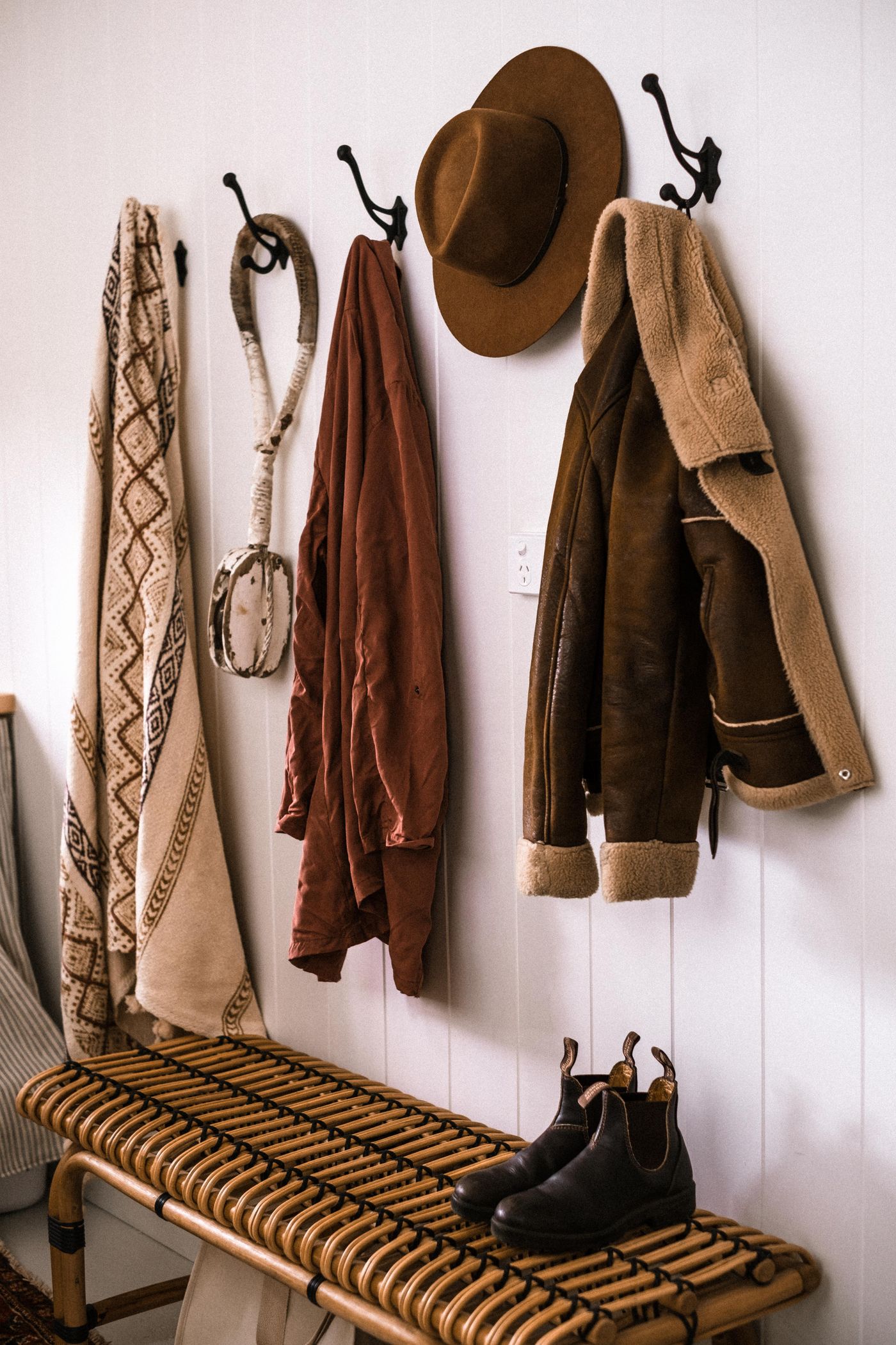 Coats and a hat hanging in a rustic entryway