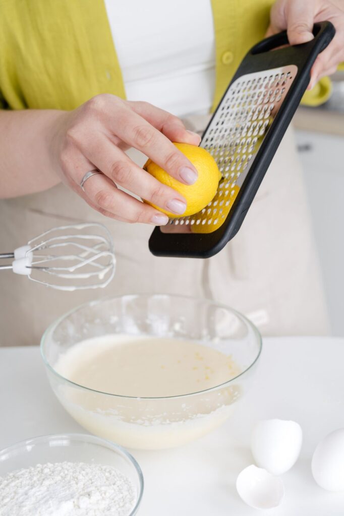 Person grating lemon zest into a bowl