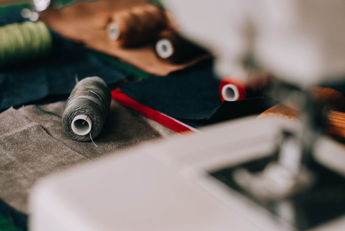 Threads, fabric and a sewing machine arranged on a work table