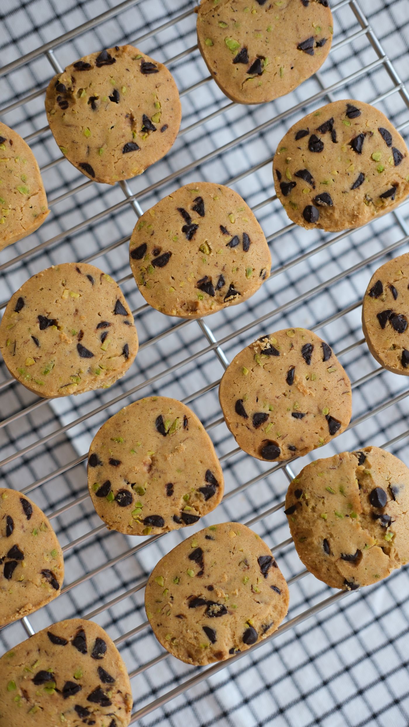 Chocolate chip cookies resting on a cooling rack