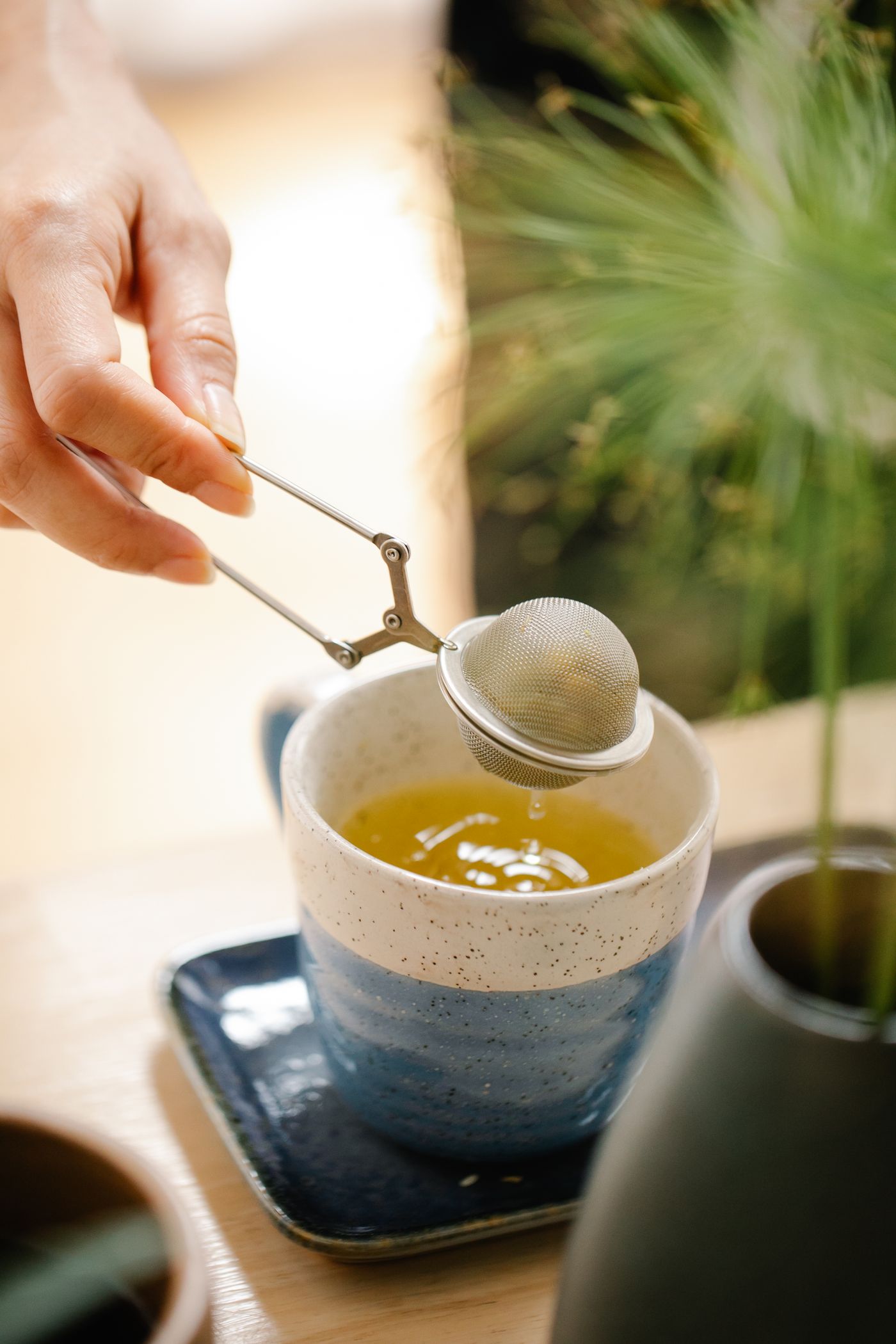 Tea infuser held above a mug